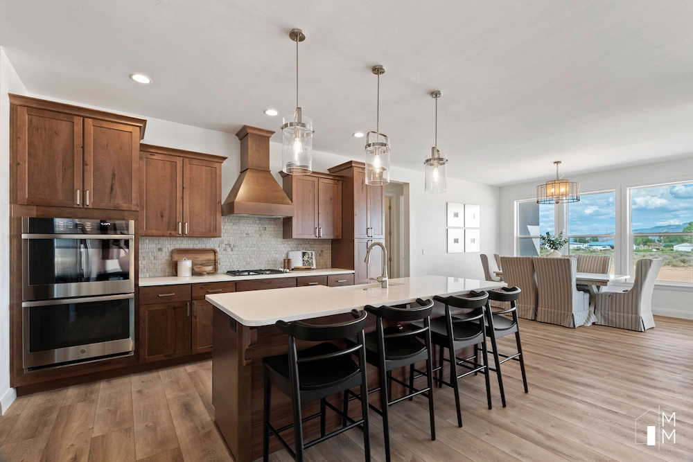 a modern kitchen with white cabinets and a maple wood floor